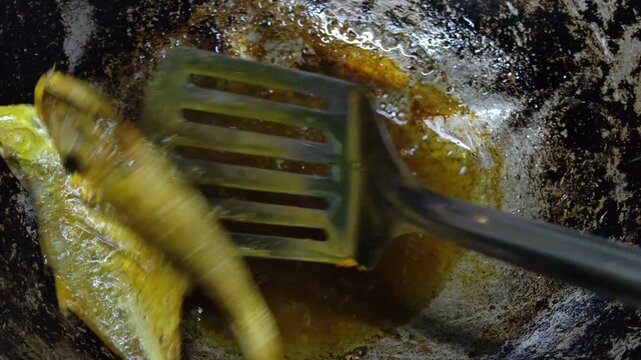 Closeup of Marinated Fish Frying in Hot Oil Inside a Wok