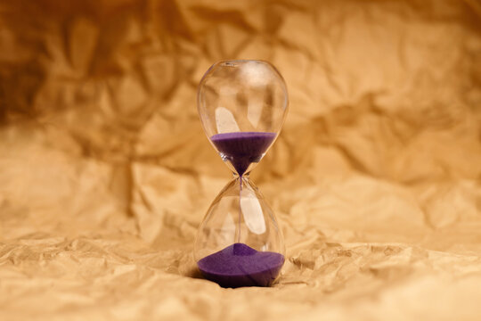 Hourglass with senior age blocks on crumpled pape,aging society, retirement and passing lifetime