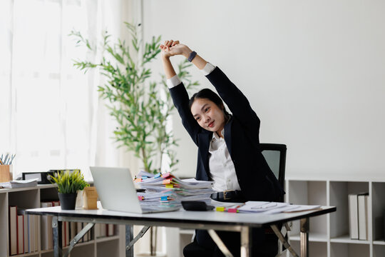 Asian business woman stretching during office break