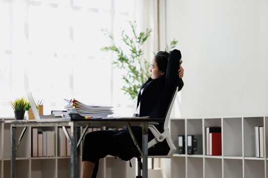 Businesswoman relaxing at desk feeling burnout from work