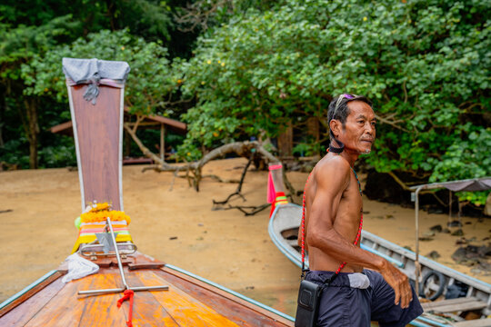 Local thai man standing by longtail boat