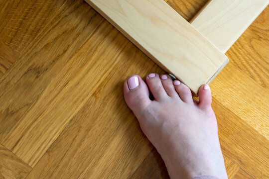 Woman hit furniture with the little toe. Incident at home. Injury of foot little finger