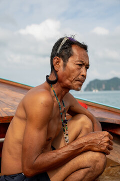 Fisherman sitting on longtail boat in thailand