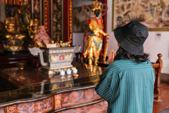 Woman praying inside a traditional asian temple