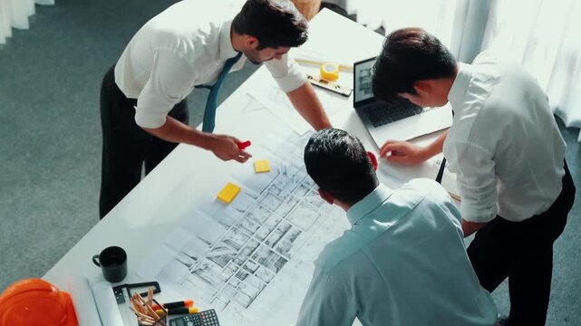 Top view of professional architect engineer team writing sticky notes and sticking note at meeting table while interior designer talking and discussing about building exterior designing. Alimentation.
