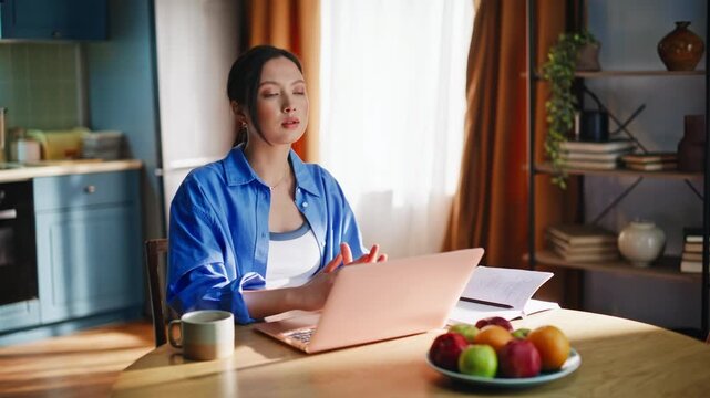 Asian girl drinking coffee working laptop home. Pensive freelancer thinking