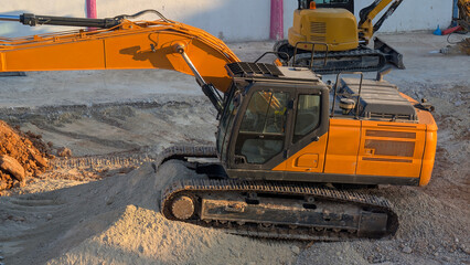 Hydraulic crawler excavator parked on excavated construction area during early morning site preparation. Heavy equipment, machinery, earthmoving, excavation, industrial engineering, contractor. © cabado