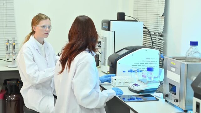 Two Female Scientists Working in Modern Research Laboratory with Equipment and Samples