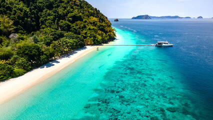 Aerial drone view of tropical landscape over Madam Beach of Nyaung Oo Phee Island with tour boat anchoring on the floating dock in the Mergui Archipelago, Myanmar. Beautiful Andaman sea in Burma © zephyr_p