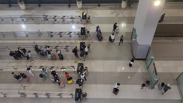 Top view of travelers standing in organized lines inside a busy airport terminal. Perfect for travel, transportation, tourism, and modern lifestyle concepts.