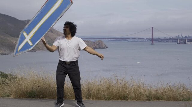Stunt Artist Spinning And Flipping Over Painted Board With View Of Golden Gate Bridge In San Francisco