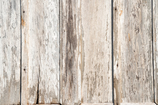 Weathered vertical wooden plank with a very worn and peeling wood veneer. Its texture is characterized by a rustic and vintage feel that is suitable for a background.