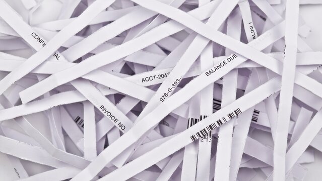 Shredded confidential white paper documents lying in a messy pile