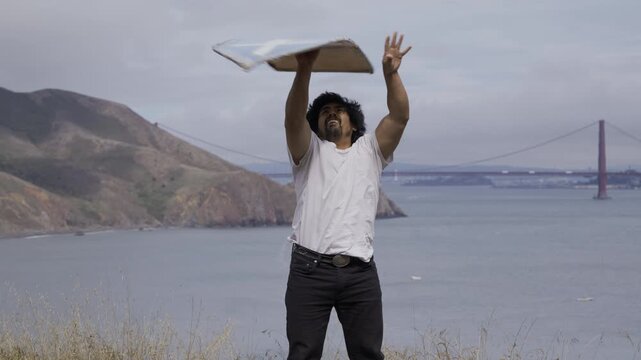 Professional Sign Spinner Throwing Large Sign into Air With View Of San Francisco Golden Gate Bridge