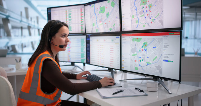 Young Female Dispatcher Using Computer Headset