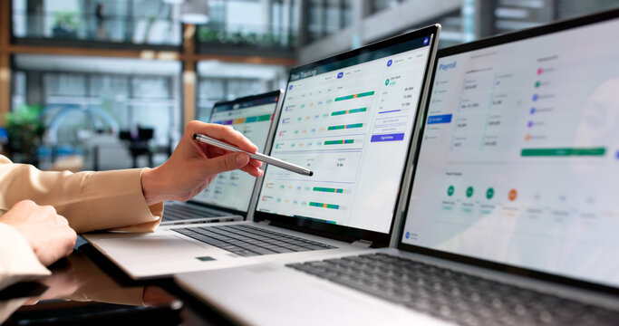 Young Woman Using Laptop To Track Employee Timesheets