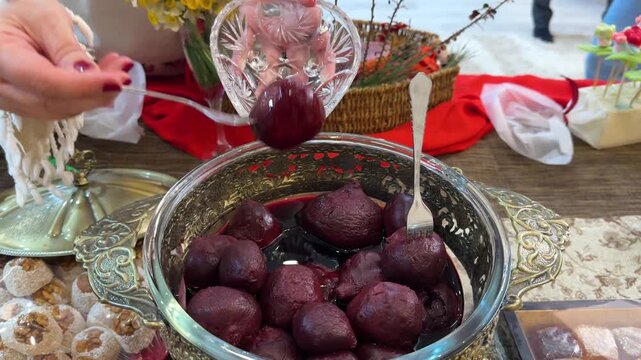Persian Yalda event ceremony of red pomegranates arranged table in crystal serving dish beetroot cooked glossy fork lifting celebration culture ruby warm symbolizing in Tehran Iran winter gathering