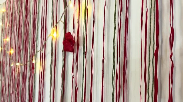 Festive scene of Yalda night Christmas eve beautiful decorative elegant red string design woven warm symbolic hanging ornament wrapped candle table artistic traditional Persian family cozy pomegranate