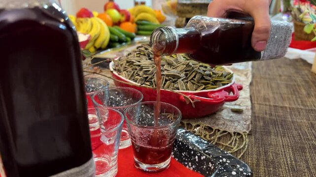 Serving red wine drink and maple syrup cherry pomegranate sorbet Yalda night table fruits traditional vibrant sweets festival and symbolism watermelon apple berries in winter cultural family gathering