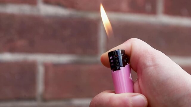 Video igniting a small pink lighter.