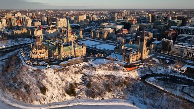 Cinematic aerial view of Parliament Hill in Ottawa Canada during winter with snow and ice.