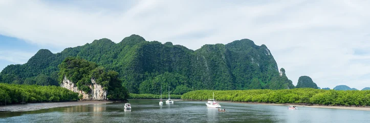 Amazing view of beautiful beach and boat with with mountains. Beautiful natural panoramic countryside landscape at sea in Thailand. © yotrakbutda