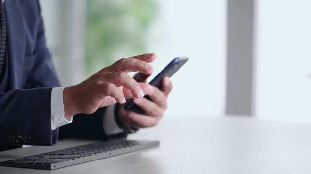 スマホとPCを使って作業する男性。アプリ、ビジネス、SNS、動画、仕事、オフィス、ERP、DX、IT