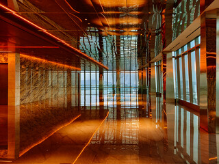 Obraz premium Spacious glass atrium with reflections on polished floor and panoramic windows. Empty lobby features