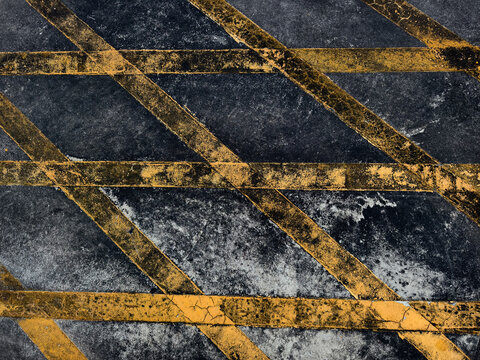 Navy textured surface crossed by gold diagonal lines, grainy indigo ground with speckled paint.