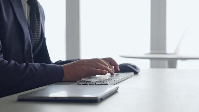 A male business professional typing on a PC keyboard. Business, DX, IT, programmer, engineer, data entry.