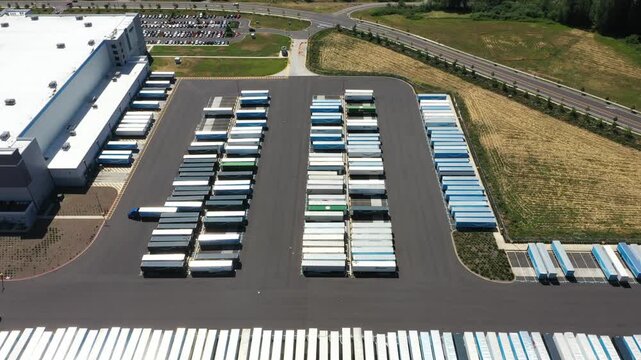4K aerial drone footage of a major ecommerce fulfillment center in Woodburn, Oregon, USA showing warehouse buildings, truck trailers, loading docks, and large-scale logistics operations