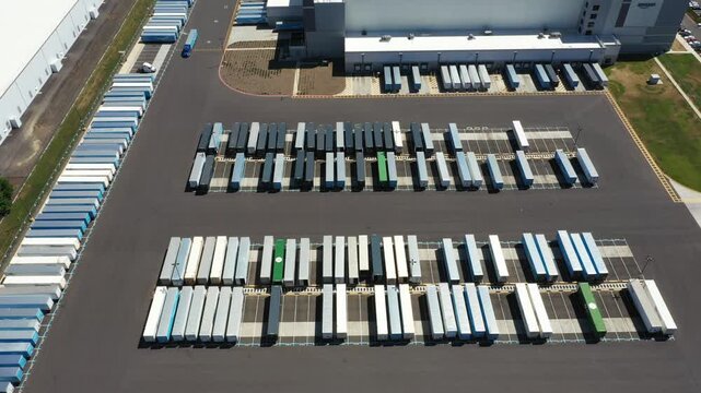 4K aerial drone footage of a major ecommerce fulfillment center in Woodburn, Oregon, USA showing warehouse buildings, truck trailers, loading docks, and large-scale logistics operations