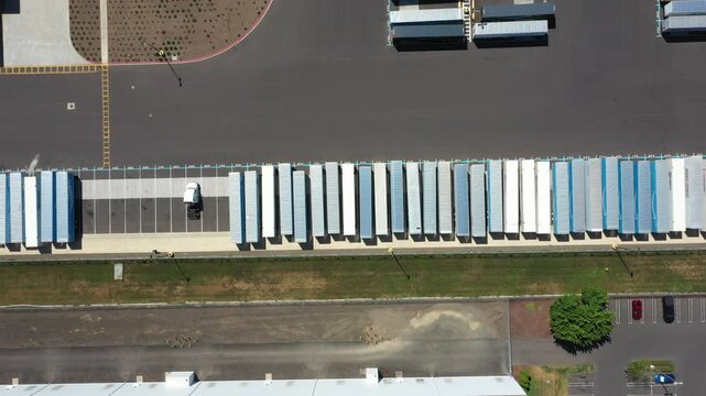 4K aerial drone footage of a major ecommerce fulfillment center in Woodburn, Oregon, USA showing warehouse buildings, truck trailers, loading docks, and large-scale logistics operations