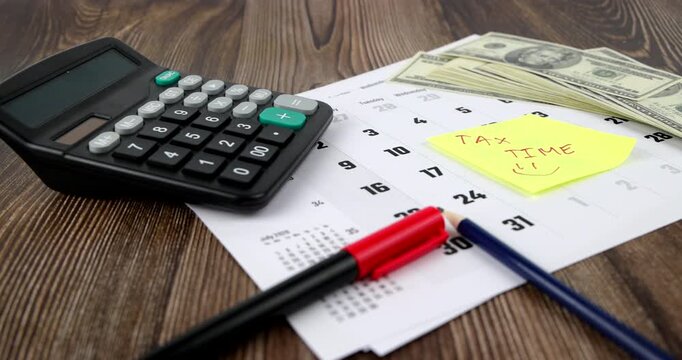 Scenic horizontal tracking view of financial auditing tools including desk calendar with stickynote message and office calculator