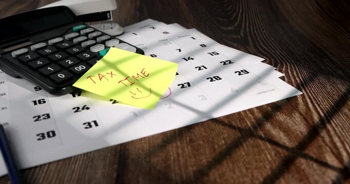 Beautiful horizontal camera movement over a brown wooden desk workspace with business calendar and office calculation equipment setup