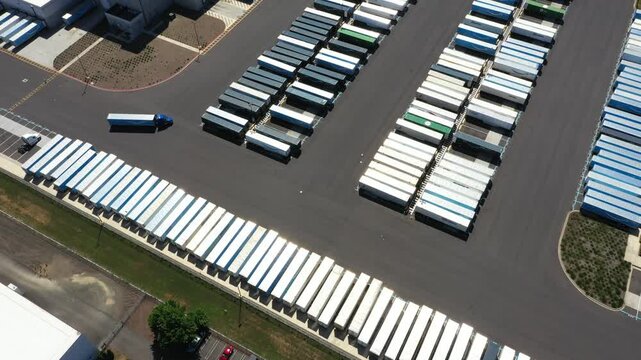 4K aerial drone footage of a major ecommerce fulfillment center in Woodburn, Oregon, USA showing warehouse buildings, truck trailers, loading docks, and large-scale logistics operations