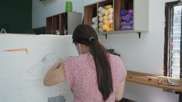 A person engaged in artistic design, skillfully working on a creative craft project, showcasing the process of creation. The environment is inspiring, filled with materials and colorful yarns.