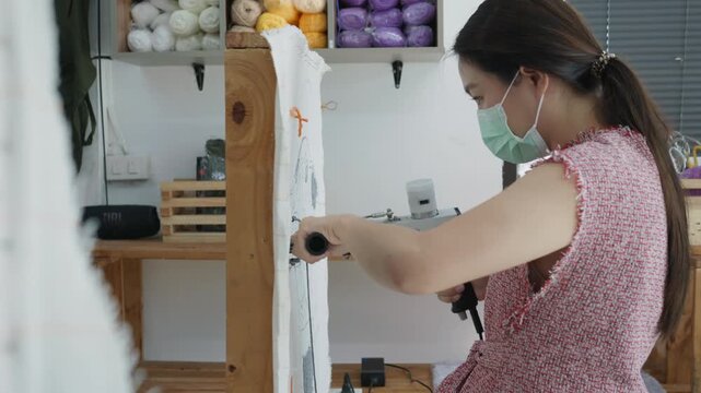 A focused individual designs unique fabrics in a bright, organized craft studio. The vibrant setting features colorful materials and tools, showcasing creativity and craftsmanship.