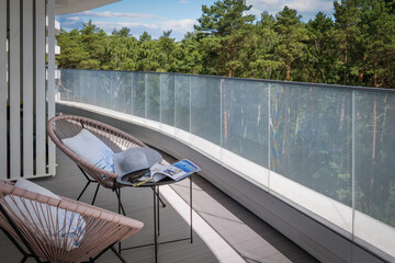 Obraz premium Modern balcony with forest view and terrace furniture