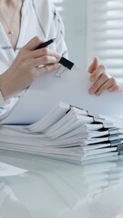 Fototapeta na wymiar Person's hands meticulously reviewing and organizing extensive business documents and financial reports fastened with binder clips. Illustrating the demanding nature of administrative work