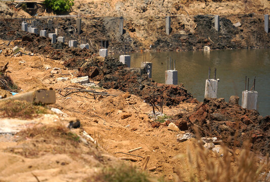 Building process city levee. Exposed foundation rebar grid at site, standing formwork and concrete footings