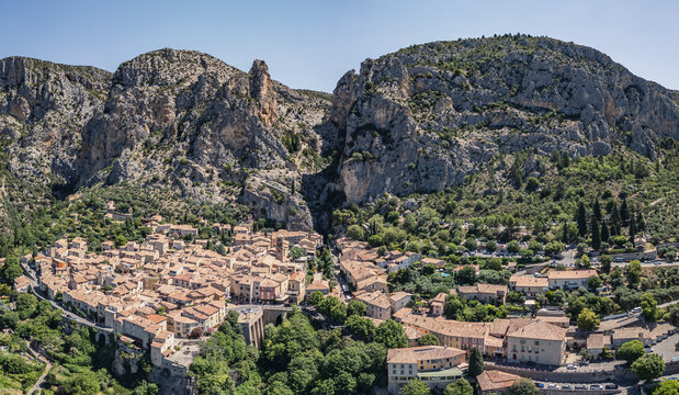 Moustiers-Sainte-Marie, France - 28 June 2026: Aerial view of Moustiers-Sainte-Marie village in a limestone gorge with historic stone buildings and terracotta rooftops.