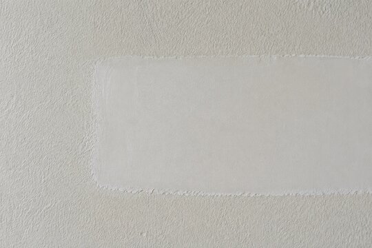 Close-up of a repaired wall showing texture difference between old and new patch.