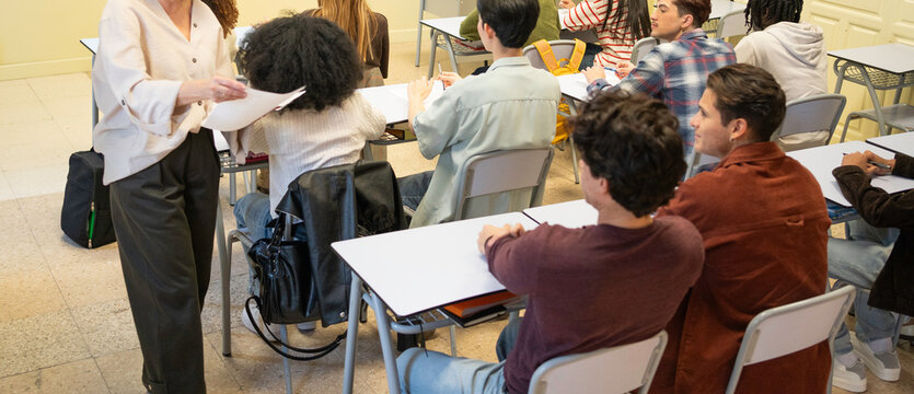 Teacher interacting with diverse students during a lesson in a modern classroom setting