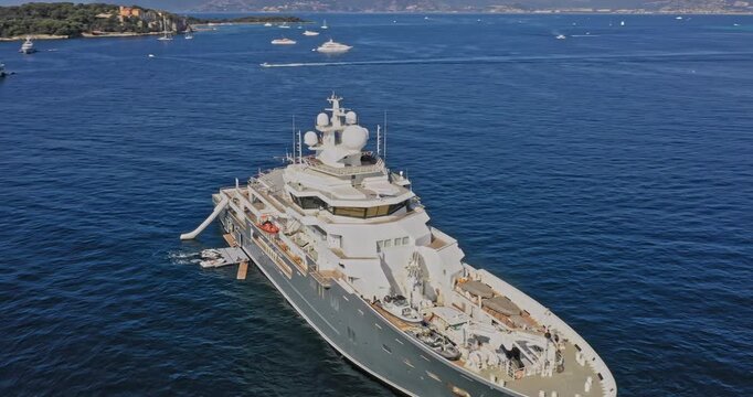 Cannes France Aerial v16 cinematic orbiting shot capturing luxurious pleasure cruise ship charter superyacht with slide on the waves and helipad floating on mediterranean sea - July 2021