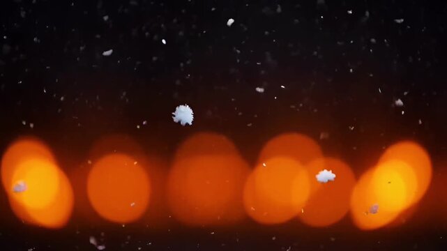 Animation snowflakes floating with soft orange bokeh lights.