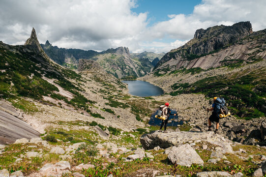 Two backpackers in the Yergaki Nature Park are looking at Paroabola and a mountain lake