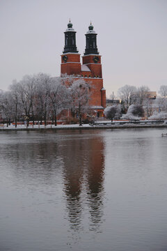 Klosters kyrka with its symmetry reflection on the Eskilstuna River in winter, Sweden.
