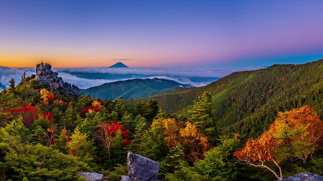 秋の奥秩父山塊天狗峰から紅葉の天狗岩の朝日に輝く天空の剣と朝焼けの富士山&larr;左方向スライド