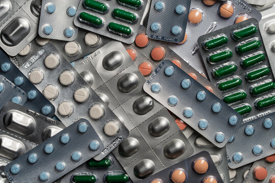 Abundance of medicine pills and capsules in blisters. Various pharmaceutical medicine pills, tablets and capsules in silver blister packs representing healthcare, pharmacy retail or medical treatment